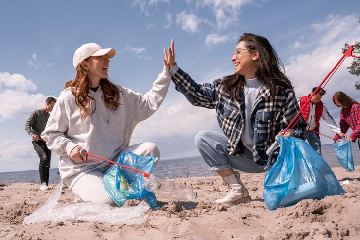 Photo de deux filles ramassant des déchets sur une plage dans le cadre d’une action écologique.