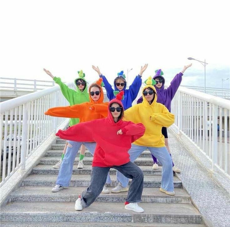 Photo de jeunes filles posant avec des vêtements colorés et un fond vif.